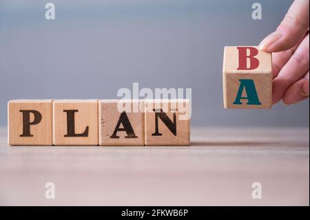 Retournez à la main le cube en bois avec le mot PLAN A pour PLAN B sur fond de bois. Concept d'entreprise Banque D'Images