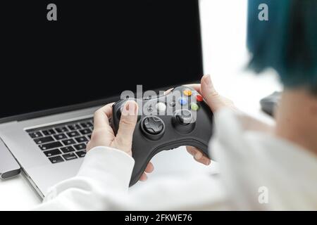 Une femme qui joue sur un ordinateur portable avec une manette de jeu. Gros plan Banque D'Images