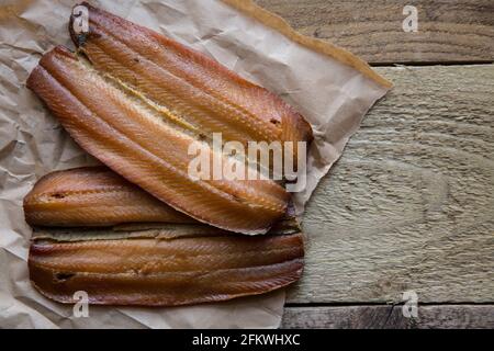 Côtelettes de cipper fumé présentées sur un fond en bois. Les kippers sont des harengs fumés et sont riches en huiles de poisson. Angleterre GB Banque D'Images