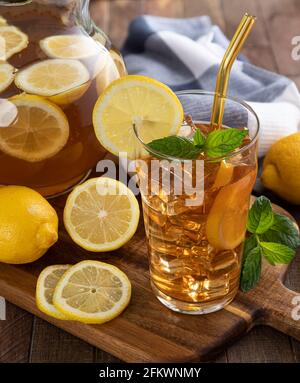 Verre de thé glacé et pichet avec tranches de citron une table en bois Banque D'Images