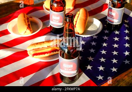 Table du 4 juillet, bouteille de bière avec étiquette originale, Happy Independence Day, hot dog classique avec catchup et moutarde, drapeau américain. Banque D'Images