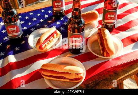 Table du 4 juillet, bouteille de bière avec étiquette originale, Happy Independence Day, hot dog classique avec catchup et moutarde, drapeau américain. Banque D'Images