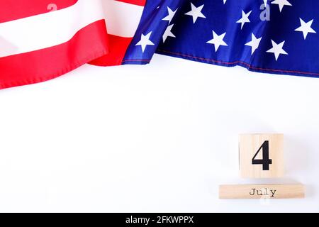 Drapeau américain à volants et calendrier en cube en bois avec date du 4 juillet. Modèle de carte de vœux Happy Independence Day sur fond d'espace de copie blanc. ÉTATS-UNIS Banque D'Images