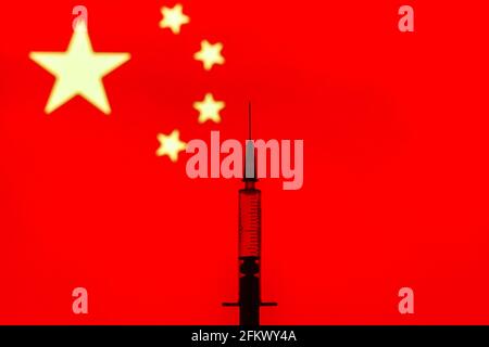 Dans cette photo, une seringue médicale est vue devant le drapeau de la Chine. Banque D'Images