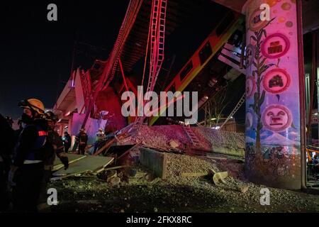Mexiko Stadt, Mexique. 04e mai 2021. Les travailleurs humanitaires et les sauveteurs se tiennent devant les décombres après l'effondrement d'une section d'un pont sur la ligne 12 du métro à Mexico. Deux voitures tombent dans une rue animée. Il y a eu des morts et des blessures. (À dpa 'près de deux douzaines de morts dans l'effondrement du pont de métro de Mexico') Credit: Jair Cabrera Torres/dpa/Alamy Live News Banque D'Images