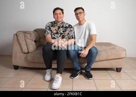 un couple de hommes assis dans leur salon vide est heureux de regarder à l'horizon Banque D'Images