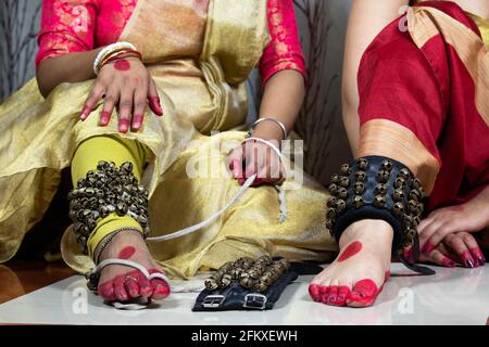 Danseuse classique indienne de filles Kathak en robe ou costume traditionnel Tie Ghungroo Ghungru ou Noopura qui est UN Anklet musical Aux pieds peints avec Banque D'Images