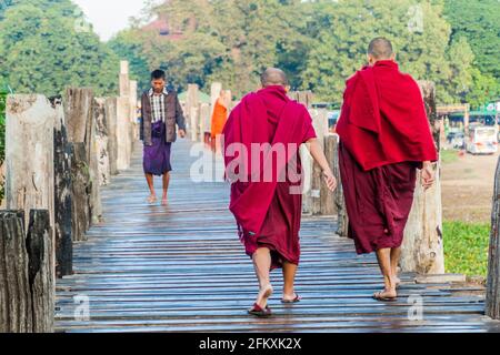 MANDALAY, MYANMAR - 4 DÉCEMBRE 2016 : des moines bouddhistes traversent le pont de U Bein au-dessus du lac Taungthaman à Amarapura, près de Mandalay, au Myanmar Banque D'Images