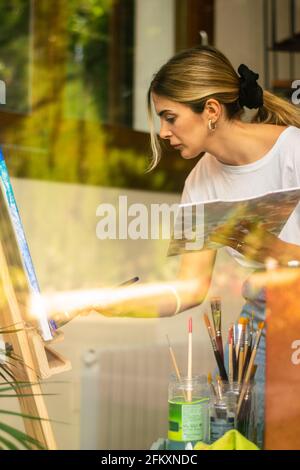 jeune fille blonde peint et prenant la palette de couleurs sur virtuel classe Banque D'Images