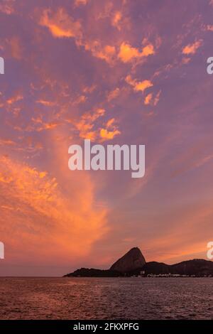 Belle vue sur le coucher du soleil aux nuages d'orange sur le pain de sucre et océan Banque D'Images