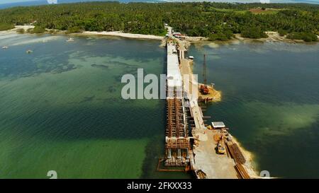 Bridge en construction sur la mer baie reliant les deux parties de l'île de Siargao. Banque D'Images