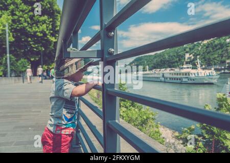 Un jeune garçon regarde des bateaux sur la rivière Banque D'Images