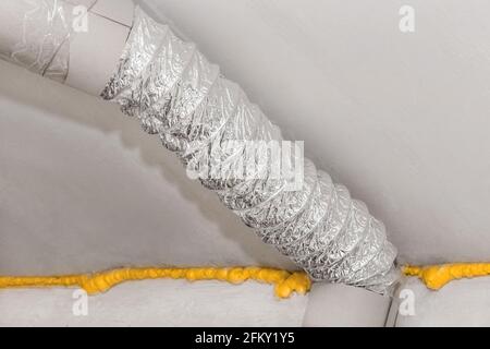Ventilation tuyau métallique d'air sous plafond avec isolation en mousse de polyuréthane de construction dans une usine ou une usine industrielle. Banque D'Images