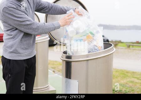 Homme jetant des conteneurs en plastique au point de recyclage. Responsabilité sociale. Concept de recyclage. Copier l'espace. Banque D'Images