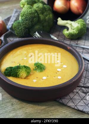 Soupe à la crème de brocoli et ingrédients sur une table en bois. Banque D'Images