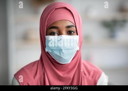 Portrait de pandémie. La dame musulmane noire dans le hijab portant un masque médical de protection Banque D'Images