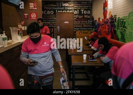 Le personnel de livraison de nourriture attend et reçoit les commandes de ses clients à l'intérieur d'un restaurant. Plusieurs villages de la capitale philippine ont été placés sous « quarantaine extrême renforcée » à la suite d’une flambée de cas de COVID-19. Manille, Philippines. Banque D'Images