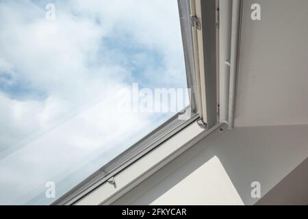 Vue rapprochée sur les puits de lumière blancs de fenêtre d'inclinaison au grenier contre le ciel bleu. Banque D'Images