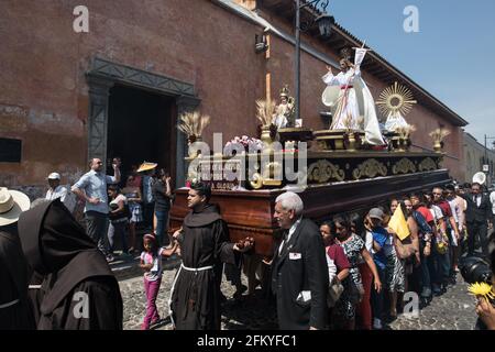 Les femmes portent un flotteur en bois élaboré (anda) lors de la procession Semana Santa à Antigua, Guatemala, une manifestation colorée de foi et de tradition. Banque D'Images