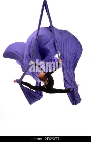 Femme flexible faisant des silks aériens trick sur le tissu Banque D'Images