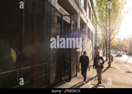 Seattle, États-Unis. 4 mai 2021. Vers la fin de la journée, les personnes passant devant la Cité de police de l'est après que la ville a commencé à enlever les barrières concrètes mises en place en août 28 2020. Les barrières ont été mises en place après que la police de Seattle ait repris le quartier des manifestants du Chop, et peu après qu'un manifestant ait déclenché un incendie à l'extérieur du côté est du bâtiment. Ils ont maintenant installé une clôture permanente de 20 pi à l'extérieur de la zone. Crédit : James Anderson/Alay Live News Banque D'Images