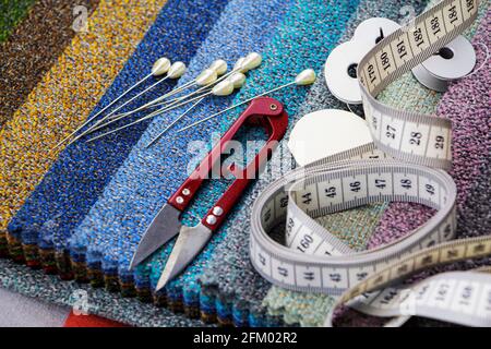 Morceaux de tissu avec ciseaux, aiguille et fil. Tailleur, fabrication de meubles rembourrés Banque D'Images