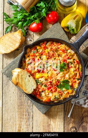 Cuisine turque traditionnelle. Mememen (légumes frits avec œuf brouillés) dans une poêle en fonte sur une table en bois. Vue de dessus de l'arrière-plan de la mise à plat COP Banque D'Images