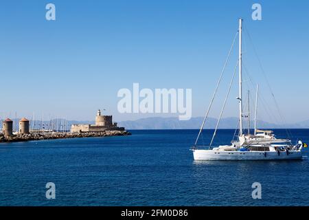 Le fort de Saint Nicolas dans la ville de Rhodes en Grèce. La forteresse du XVe siècle iis sur un mur de port avec les trois moulins en pierre de Mandraki par Banque D'Images