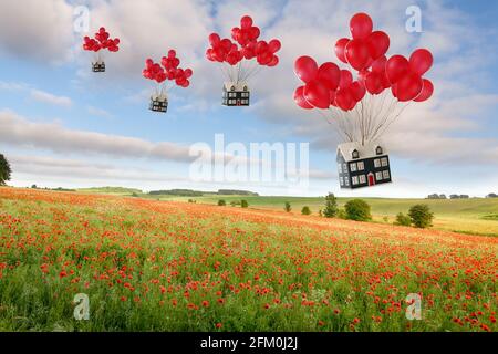 Maisons attachées à des ballons rouges flottant sur un magnifique champ de pavot. Concept de maison de déménagement et d'agent immobilier Banque D'Images