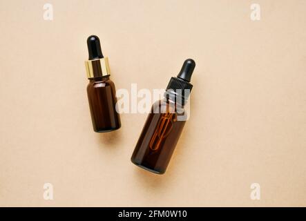 Deux flacons compte-gouttes en verre brun foncé à usage médical et cosmétique sur fond clair. Concept SPA. Vue de dessus, espace de copie Banque D'Images