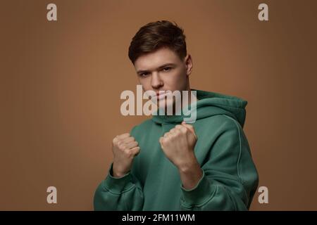 jeune homme en sweat-shirt avec geste de boxe Banque D'Images