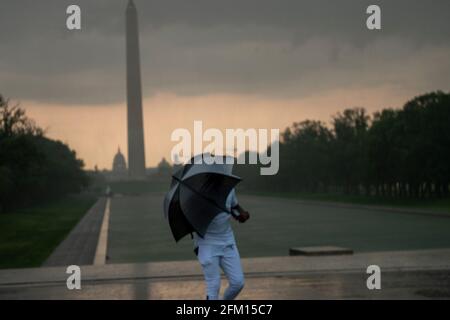 Washington, États-Unis. 04e mai 2021. Un homme se protège de la pluie lorsqu'un orage a traversé Washington, DC l'après-midi du 4 mai 2021. (Photo de Tony Peltier/Sipa USA) crédit: SIPA USA/Alay Live News Banque D'Images