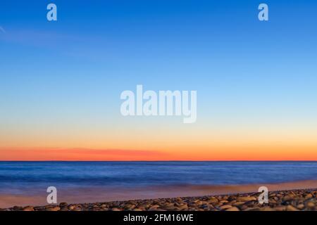 Beau résumé horizon coucher de soleil ciel ton flou fond, bleu orange motif. Ciel clair et dégradé au coucher du soleil sur la mer. Banque D'Images