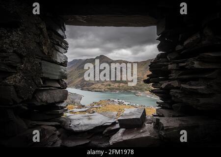 Belle vue sur le paysage du mont Snowden à travers la fenêtre des mineurs abandonnés bothie cottage Dinorwic carrière d'ardoise au nord du pays de Galles. Maison des mineurs abandonnée Banque D'Images