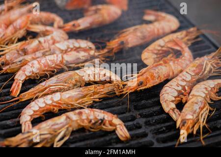 Processus de cuisson des crevettes fraîches rouges langoustine, crevettes sur le gril - nourriture de rue Banque D'Images