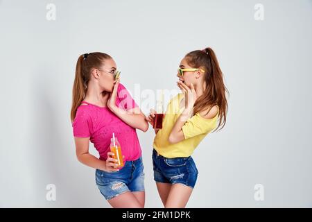 Portrait en gros plan de deux personnes sympa mignon frais fascinant charmant séduisant charmant gai filles dans des vêtements décontractés avec boisson isolée plus de Banque D'Images