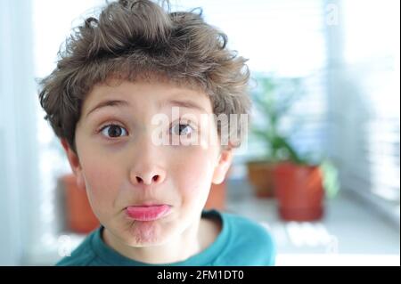 Mignon petit garçon fait des visages drôles Banque D'Images