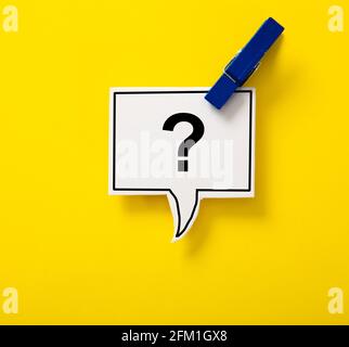 Clip en bois bleu avec bulle de discours question Mark isolé sur fond jaune. Banque D'Images