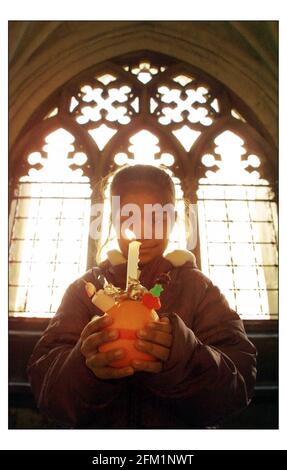 Les enfants de l'école de l'église St Barnabas d'Angleterre, Pimlico, se préparer à participer aux célébrations annuelles de Christingle Childrens Societys à l'abbaye de Westminster. Le thème de cette année est briller une lumière sur BullyingLe Orange symbolise le monde, le ruban rouge le sang du Christ et la bougie la lumière du monde. pic David Sandison 28/11/2002 Banque D'Images