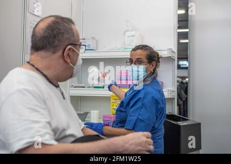 Barcelone, Espagne. 5 mai 2021. L'homme parle avec l'infirmière avant de recevoir la dose de vaccin COVID19. Pour accélérer la vaccination COVID-19 et les centres de soins primaires les plus décongestionnant, l'institution du salon de Barcelone, Fira Barcelona, est devenue depuis avril 30 un centre de vaccination de masse. Il est le premier en Catalogne à pouvoir administrer jusqu'à 120,000 vaccins par semaine. Cet espace est ajouté aux cinquante espaces municipaux autorisés par le Conseil municipal de Barcelone comme espaces de vaccination COVID-19. Crédit : SOPA Images Limited/Alamy Live News Banque D'Images