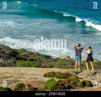 Couple debout sur le rocher de granit surplombant Cable Beach Torndirrup péninsule de Torndirrup Parc national d'Albany Australie occidentale. Banque D'Images