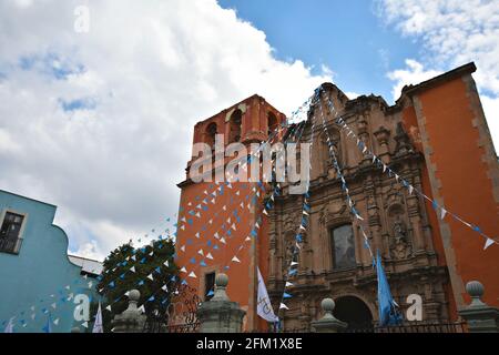 Vue extérieure panoramique sur le Parroquia del Inmaculado Corazón de María (Belén) de style baroque avec des banderoles colorées au Guanajuato Mexique. Banque D'Images