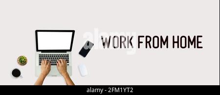 Main utilisant l'ordinateur portable d'en haut sur l'arrière-plan. Vue de dessus Work from Home Word. Banque D'Images