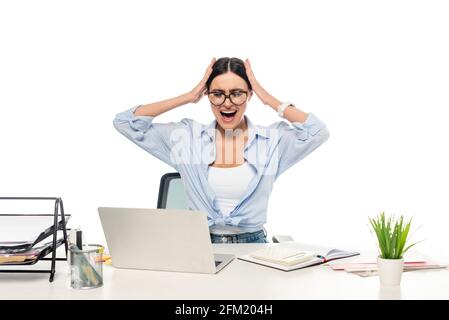 une femme d'affaires surtraitée se touchant la tête et criant sur un lieu de travail isolé blanc Banque D'Images