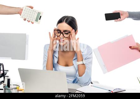 une femme d'affaires fatiguée se touchant la tête sur le lieu de travail à proximité de personnes avec des documents isolé sur blanc Banque D'Images
