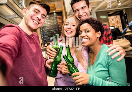 Des amis multiraciaux prenant du selfie et buvant de la bière dans une brasserie de fantaisie Restaurant - concept d'amitié avec les jeunes qui apprécient le temps ensemble Banque D'Images