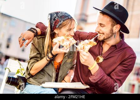 Jeune couple hippster manger de la pizza au bar restaurant à l'extérieur - Concept de bonne relation avec un petit ami et une petite amie millenial qui s'amusent moments Banque D'Images