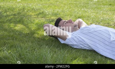 Jeune homme caucasien couché sur l'herbe Banque D'Images