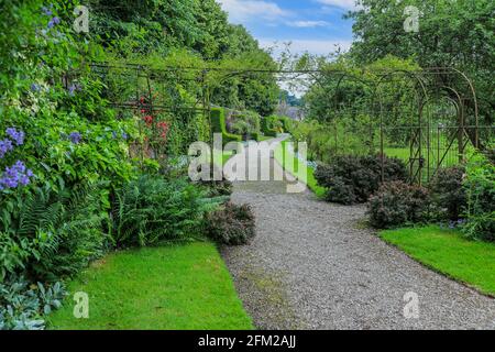 Un chemin de gravier à travers les frontières herbacées à Weston Park, Weston-sous-Lizard, près, Staffordshire, Angleterre, ROYAUME-UNI. Banque D'Images