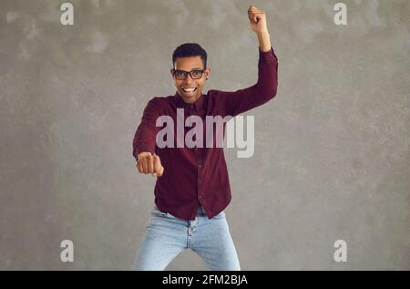 Un jeune homme afro-américain se réjouit de son succès avec un studio de poings serrés prise de vue Banque D'Images